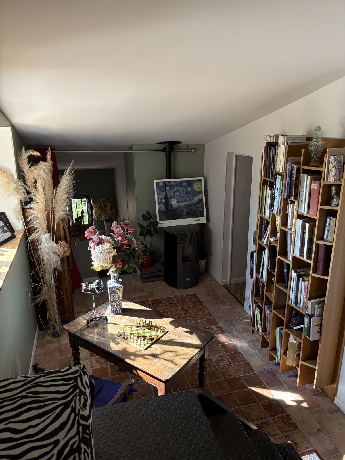 Le coin lecture, sa bibliothèque et son poêle