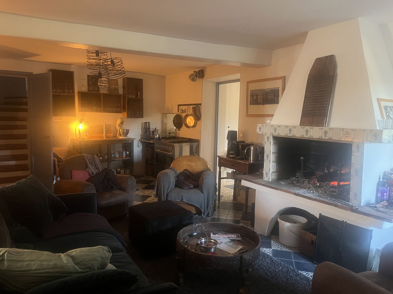 Le salon et sa cheminée, ouvert sur la cuisine