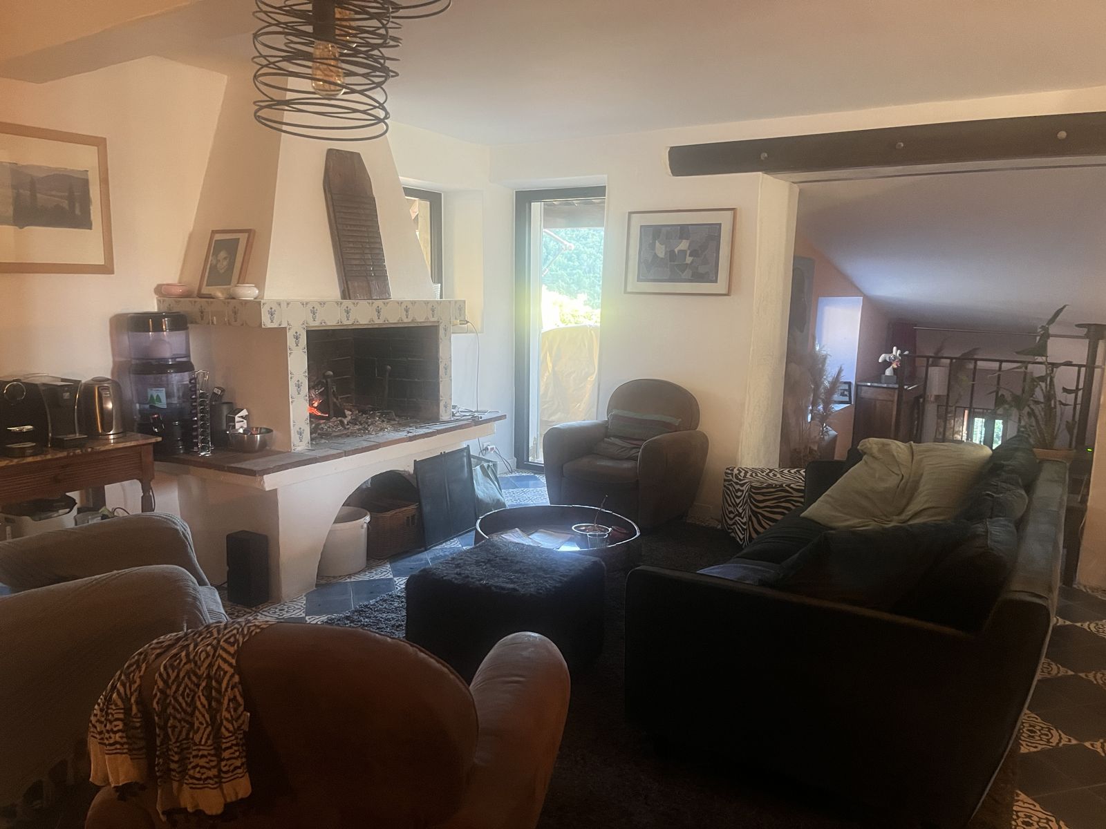 Le salon, sa cheminée et la porte-fenêtre sur la terrasse