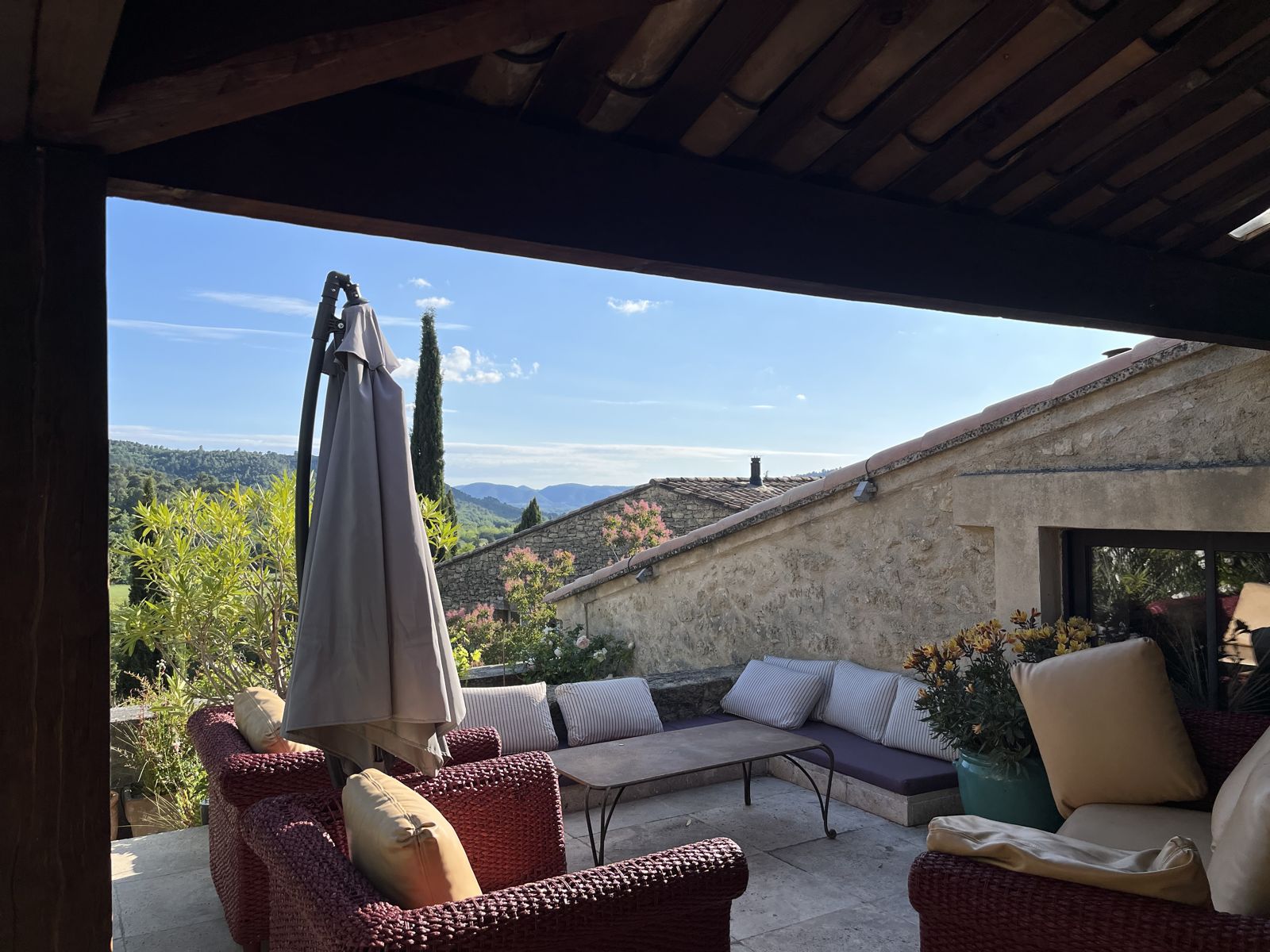 Le salon de terrasse sous la pergola, vue sur les collines