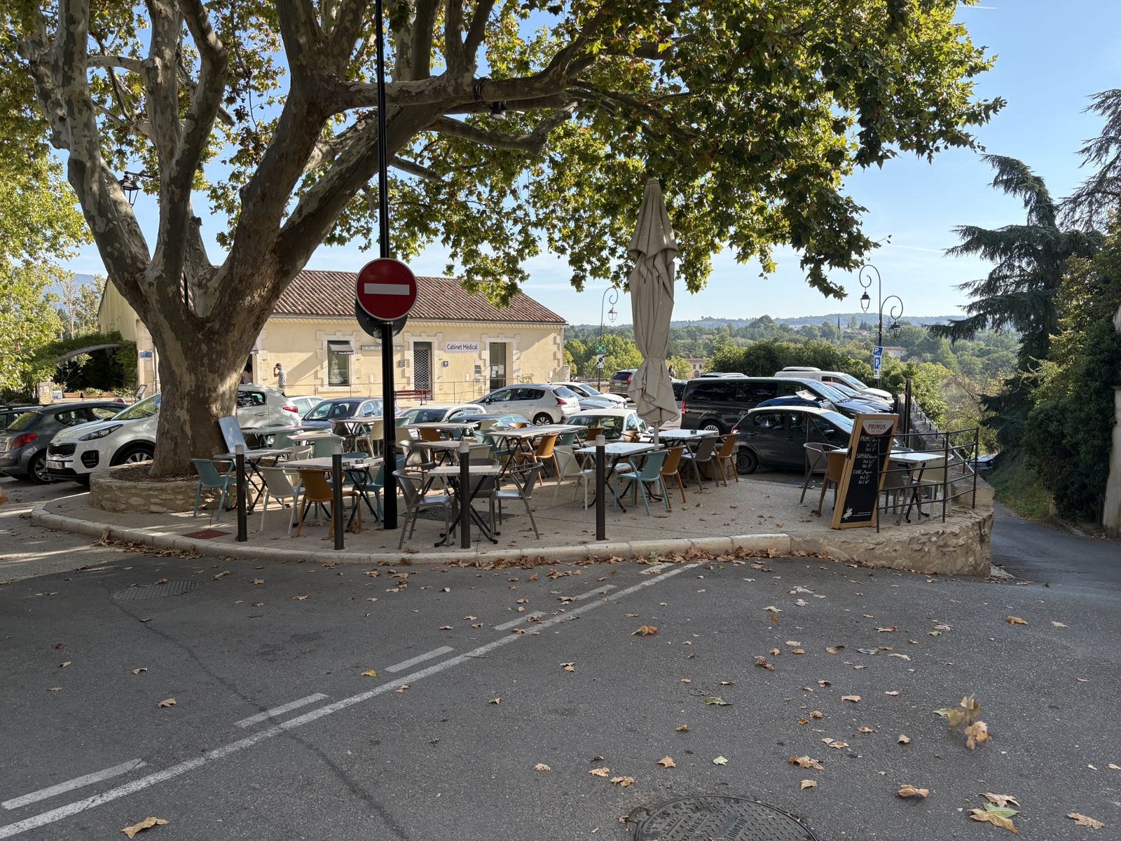 Une terrasse de café à l’ombre du platane, face à la campagne